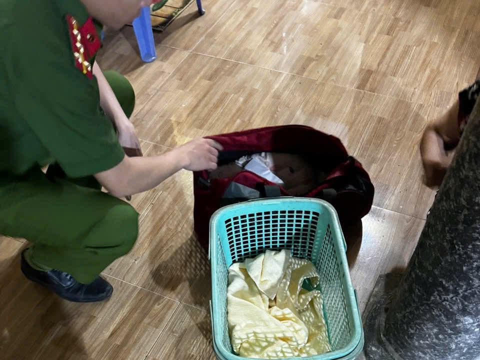 Bé gái bị bỏ lại trong giỏ xách, bên cạnh là quần áo và bức thư tay. Ảnh: CA phường Tây Hoa Lư