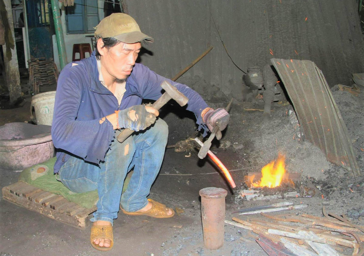 Những người thợ hàn miệt mài làm việc dưới cái nắng nóng. Ảnh: Tấn Thành.