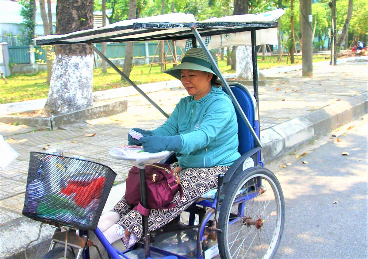 Người bán vé số tìm chỗ bóng mát tránh nắng nóng trên đường Nguyễn Chí Thanh, phường Bàn Thạch. Ảnh: Tấn Thành.