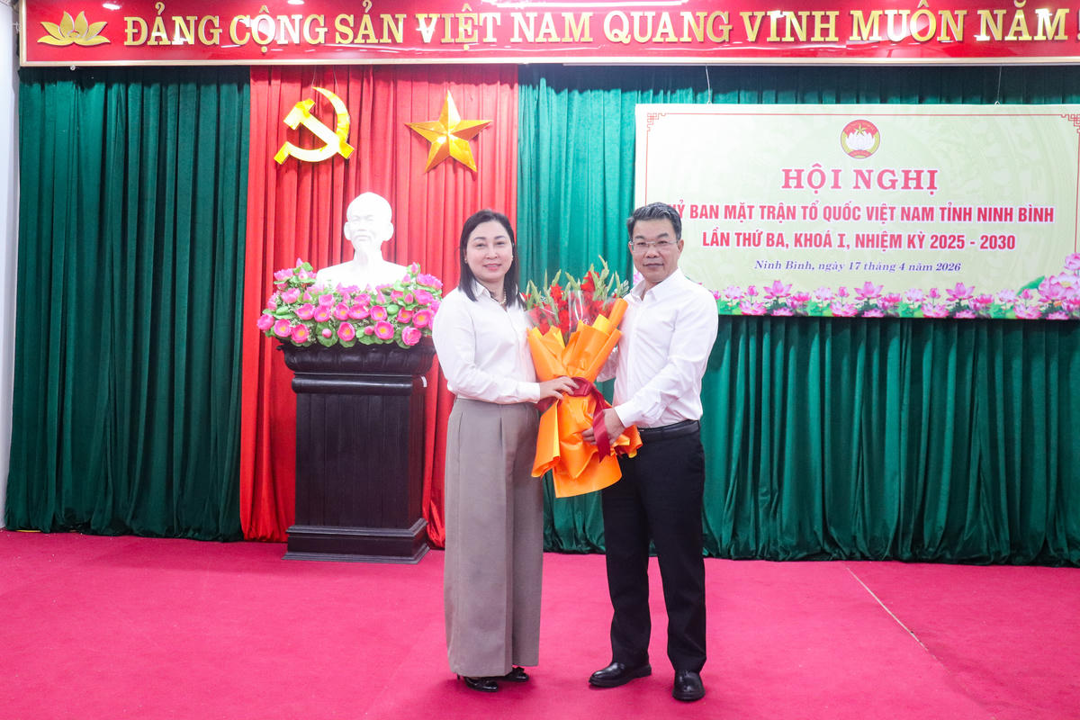 Thay mặt Ban Thường trực Ủy ban MTTQ tỉnh, ông Nguyễn Hoàng Hà - Phó Chủ tịch Thường trực Ủy ban MTTQ tỉnh tặng hoa chúc mừng bà Đinh Thị Lụa. Ảnh: Đình Minh