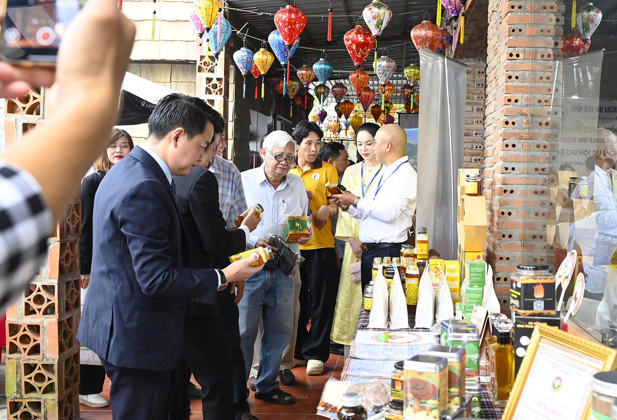 Đại biểu tham quan gian hàng trưng bày sản phẩm quà tặng cho du khách. Ảnh Nguyễn Minh.
