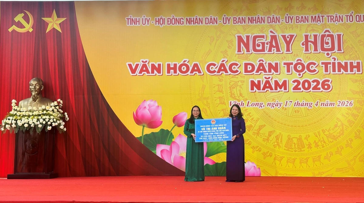 Phó Chủ tịch nước Võ Thị Ánh Xuân trao bảng tượng trưng tặng 10 căn nhà Đại đoàn kết cho tỉnh Vĩnh Long. (Ảnh: Trung Ngãi).