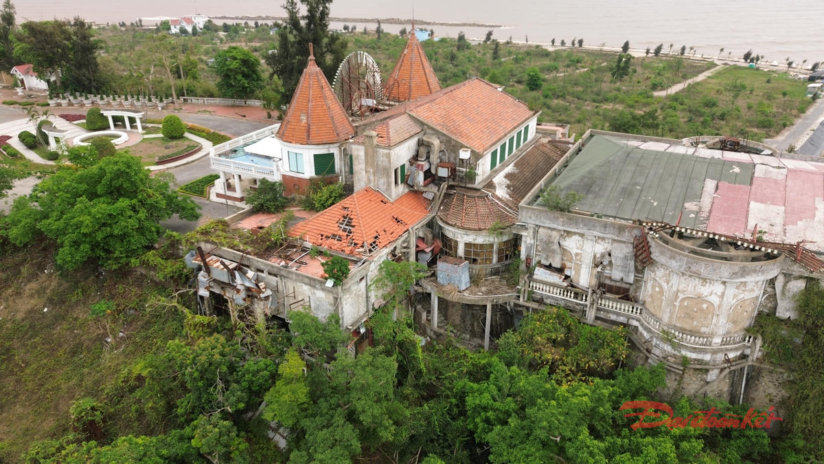 Từ trên cao nhìn xuống, phần mái ngói màu cam truyền thống đã bị hư hỏng nhiều khu vực. Hành lang, lối đi phủ kín rêu phong. Ảnh: PT. 