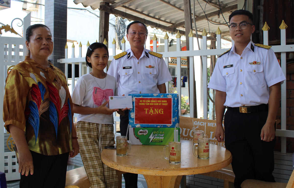 Thượng tá Nguyễn Hùng Vỹ, Phó Chính ủy Trung tâm Bảo đảm kỹ thuật trao quà cho cháu Nguyễn Ngọc Nhi. Ảnh: Đình Sơn.