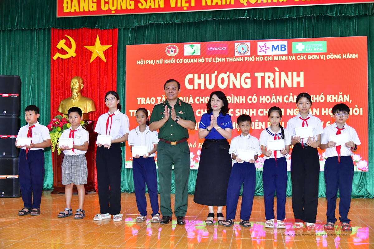 Thiếu tướng Vũ Văn Điền, Ủy viên Ban Thường vụ Thành ủy, Tư lệnh Bộ Tư lệnh thành phố tặng học bổng cho các em học sinh. Ảnh: Hữu Tân.
