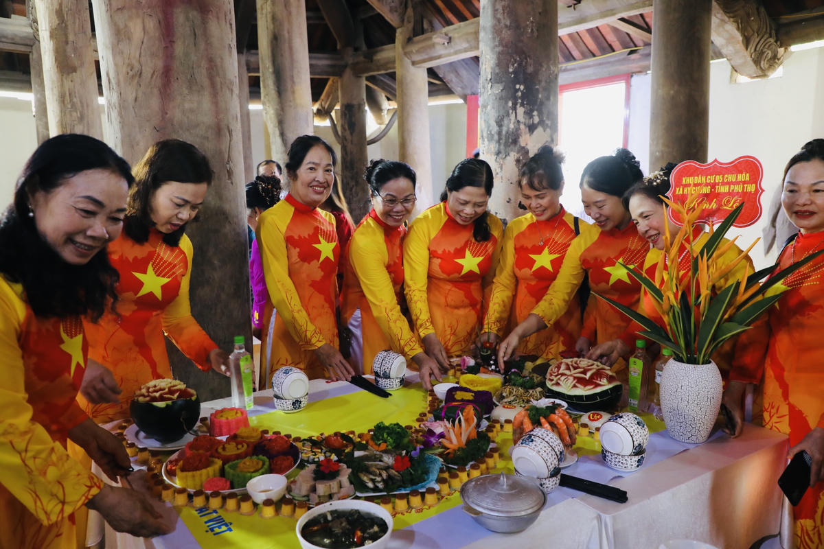 Các thành viên Ban Công tác Mặt trận ở khu dân cư thể hiện khéo léo trưng bày mâm cỗ. Ảnh: Tùng Duy.