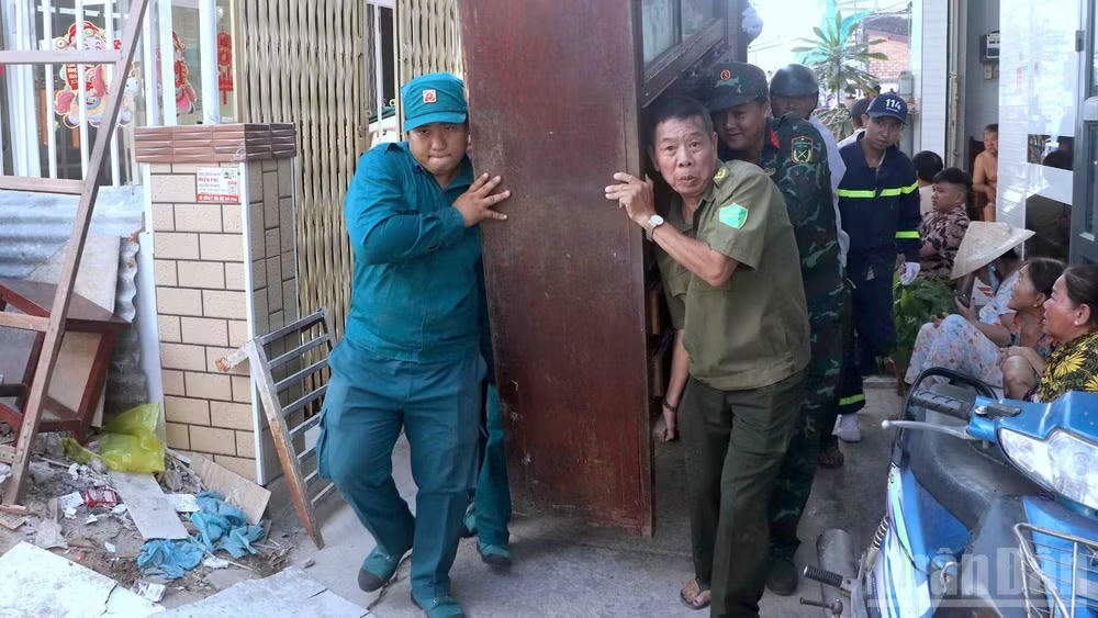 Lực lượng chức năng phường Tân Thành hỗ trợ người dân di dời đồ đạc đến nơi ở mới sau vụ sạt lở. Ảnh: CTV