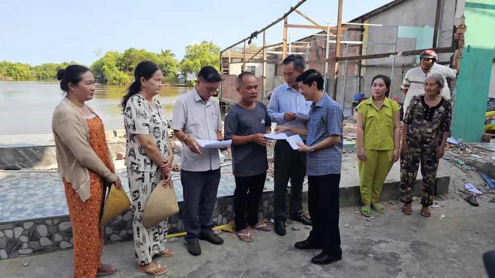 Bí thư Đảng ủy phường Tân Thành (tỉnh Cà Mau) trao hỗ trợ cho các hộ dân có nhà bị ảnh hưởng bởi sạt lở đất. Ảnh: CTV.