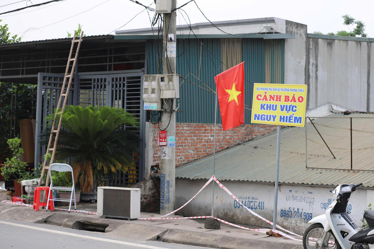 Lực lượng chức năng cắm biển cảnh báo khu vực nguy hiểm tại nơi xảy ra sự cố sụt lún. Ảnh: Đ.A.