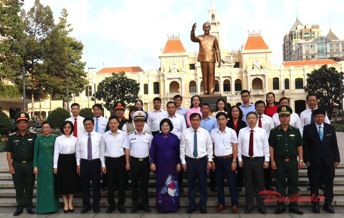 Đoàn chụp ảnh lưu niệm trước tượng đài Chủ tịch Hồ Chí Minh trên Phố đi bộ Nguyễn Huệ. Ảnh: T.Luân.