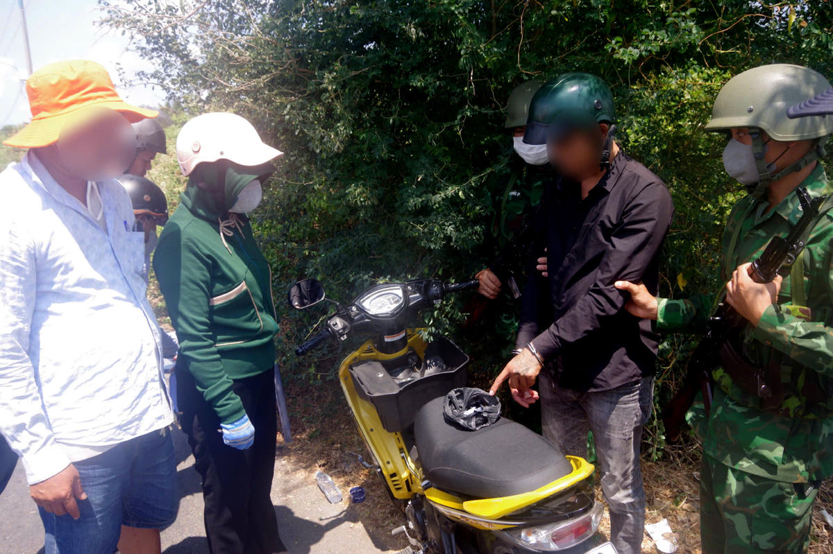 Lực lượng phối hợp với người dân bắt đối tượng H. cùng tang vật. (Ảnh: Trần Giỏi).