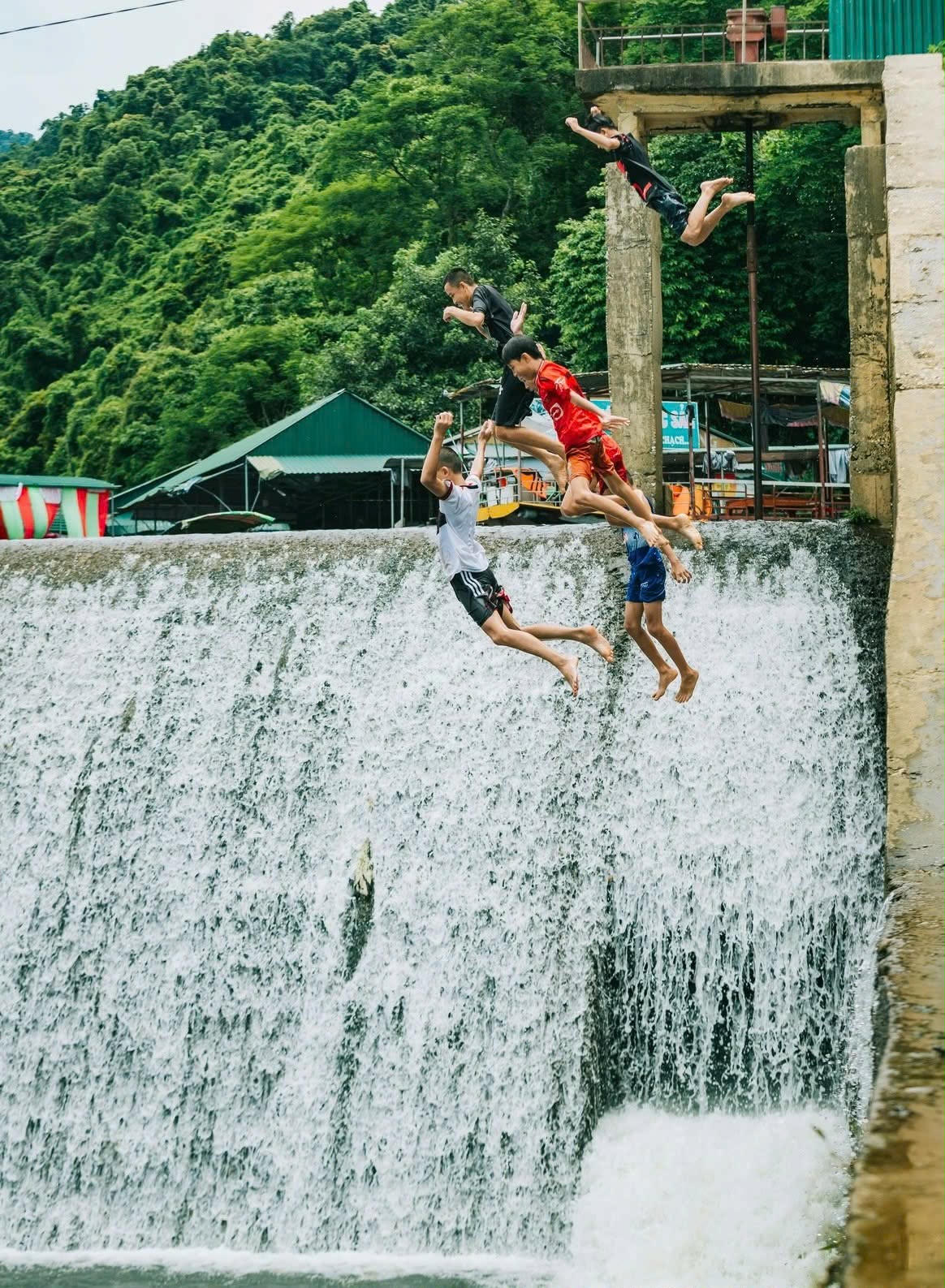 Trẻ em nhảy từ trên thân đập xuống tại đập Phả Lài, xã Môn Sơn (Nghệ An). Ảnh: Công Sáng