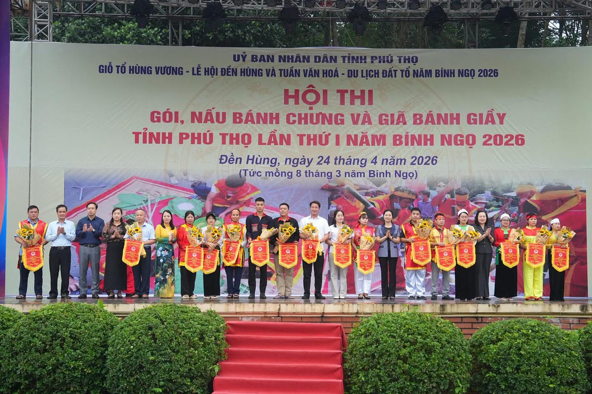 Bà Bùi Thị Minh, Phó Bí thư Tỉnh ủy, Chủ tịch Ủy ban MTTQ Việt Nam tỉnh Phú Thọ trao cờ và tặng hoa cho các đội nghệ nhân. Ảnh: Tùng Duy.