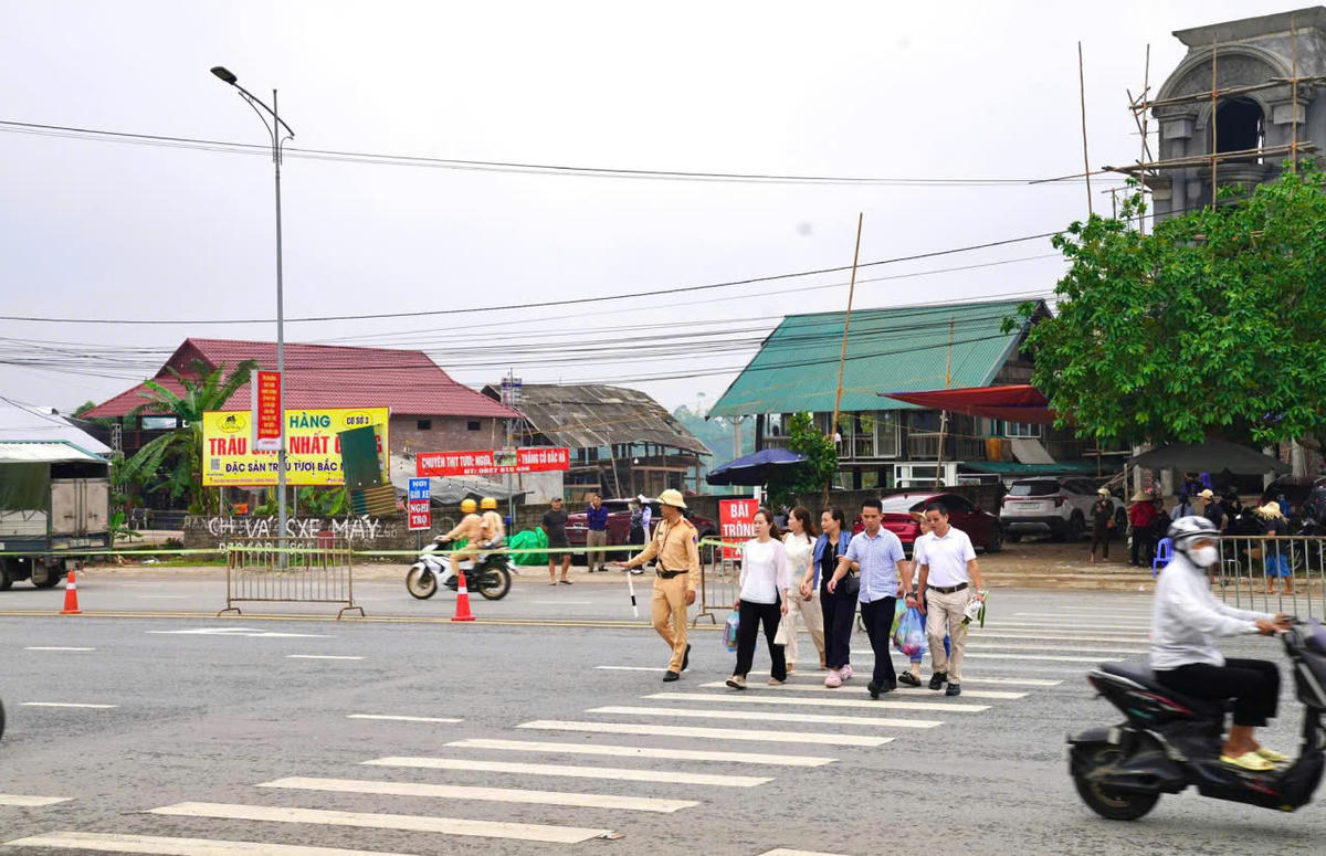 Không chỉ phân luồng, đảm bảo an toàn giao thông, lực lượng Cảnh sát giao thông (Công an tỉnh Phú Thọ) còn giúp người dân qua đường an toàn. Ảnh: CACC.