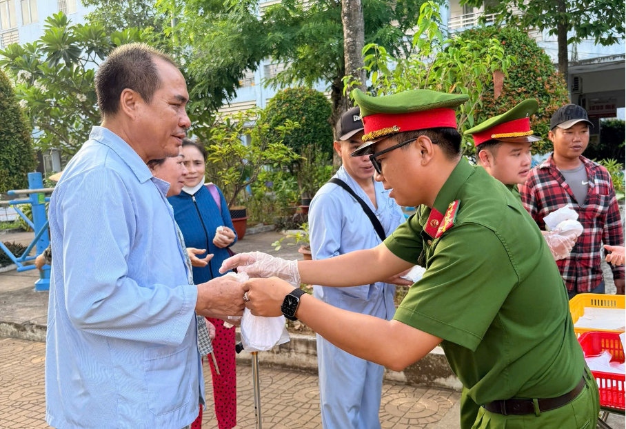 Đoàn viên thanh niên Công an tỉnh An Giang trao suất ăn cho bệnh nhân tại&nbsp;Bệnh viện Y dược Cổ truyền Kiên Giang. Ảnh: Văn Vũ