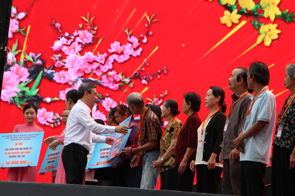 Ông Nguyễn Phước Lộc - Ủy viên Trung ương Đảng, Phó Bí thư Thành ủy, Chủ tịch Ủy ban MTTQ Việt Nam TP Hồ Chí Minh trao bảng hỗ trợ kinh phí cho các hộ có hoàn cảnh khó khăn sửa nhà Đại đoàn kết tại Ngày hội “Xuân đoàn kết - Tết nghĩa tình” - Tết Bính Ngọ 2026. Ảnh: Q.Đ.