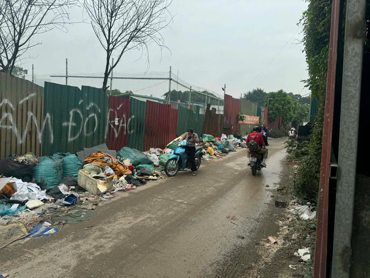 Một người dân suýt ngã vì tránh đống rác trên đoạn đường này.