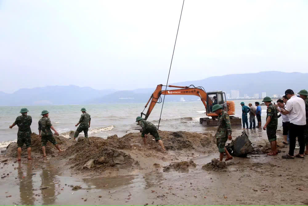 Lực lượng chức năng tỉnh Gia Lai đang trục vớt xác xe tăng tại bãi biển Quy Nhơn. Ảnh: HP.