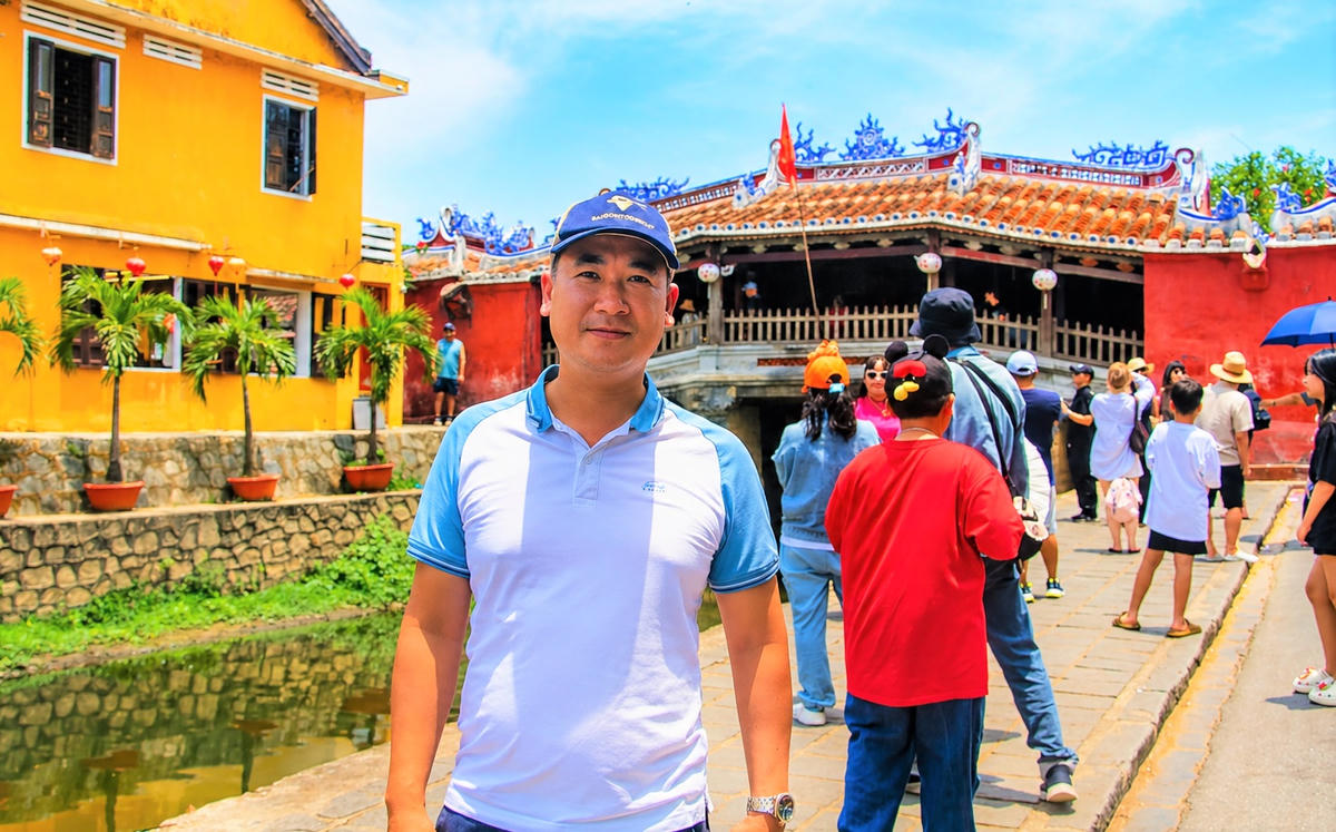 Anh Đặng Hữu Anh chụp ảnh lưu niệm bên chùa Cầu Hội An. Ảnh: Tấn Thành.