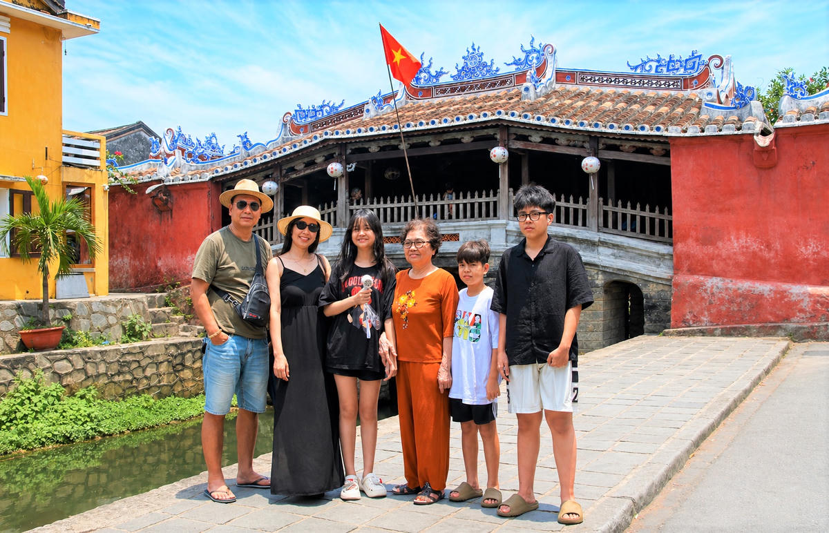 Một gia đình chụp ảnh lưu niệm bên chùa Cầu Hội An. Ảnh: Tấn Thành.