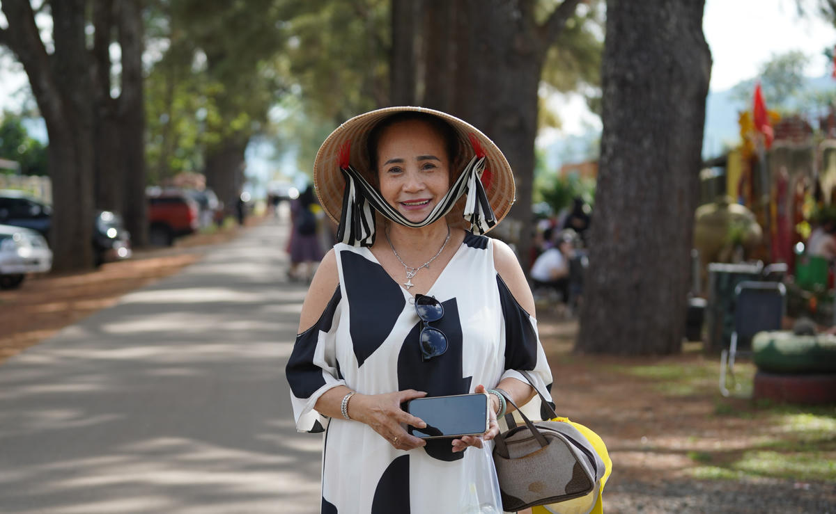 Bà Yến Hòa chụp ảnh lưu niệm nơi hàng thông trăm tuổi. Ảnh: Đình Sang.