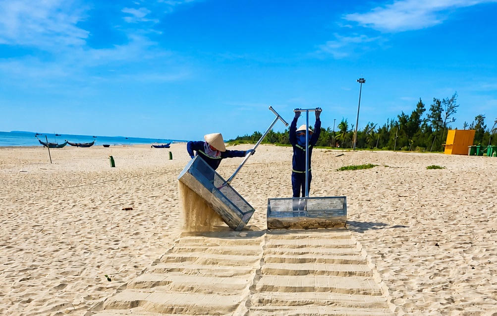 Công nhân thu gom rác thải dọc bờ biển Tam Thanh, phường Quảng Phú. Ảnh: Tấn Thành.