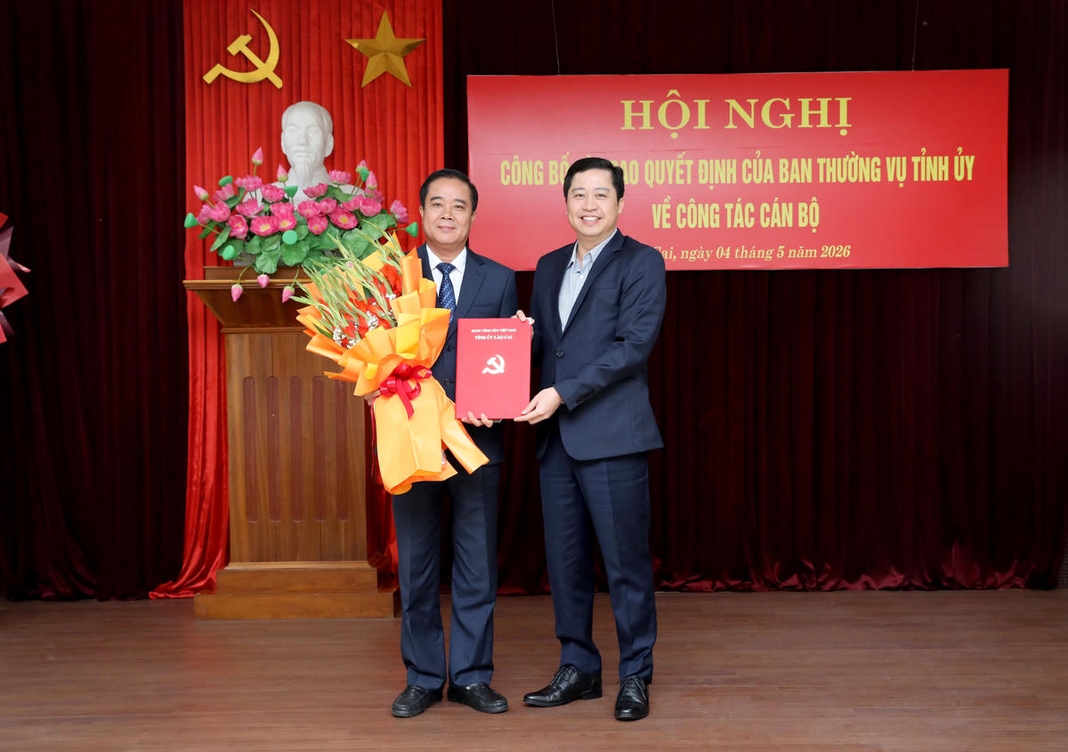 Ông Dương Quốc Huy - Ủy viên Ban Chấp hành Trung ương Đảng, Bí thư Tỉnh ủy Lào Cai trao Quyết định và tặng hoa chúc mừng ông Phan Đăng Toàn. Ảnh: laocai.gov.vn.