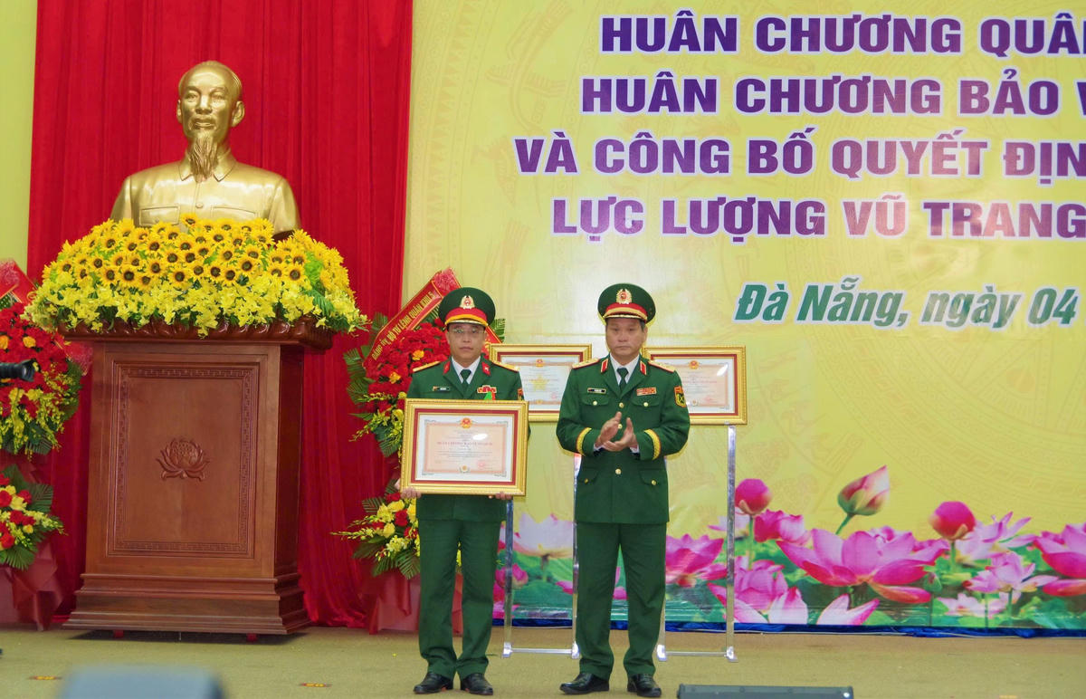 Trung tướng Lê Ngọc Hải, Tư lệnh Quân khu 5 trao Huân chương Bảo vệ Tổ quốc hạng Ba tặng Đại tá Trần Hữu Ích (bên trái), Chỉ huy trưởng Bộ CHQS TP Đà Nẵng. Ảnh: Tấn Thành.