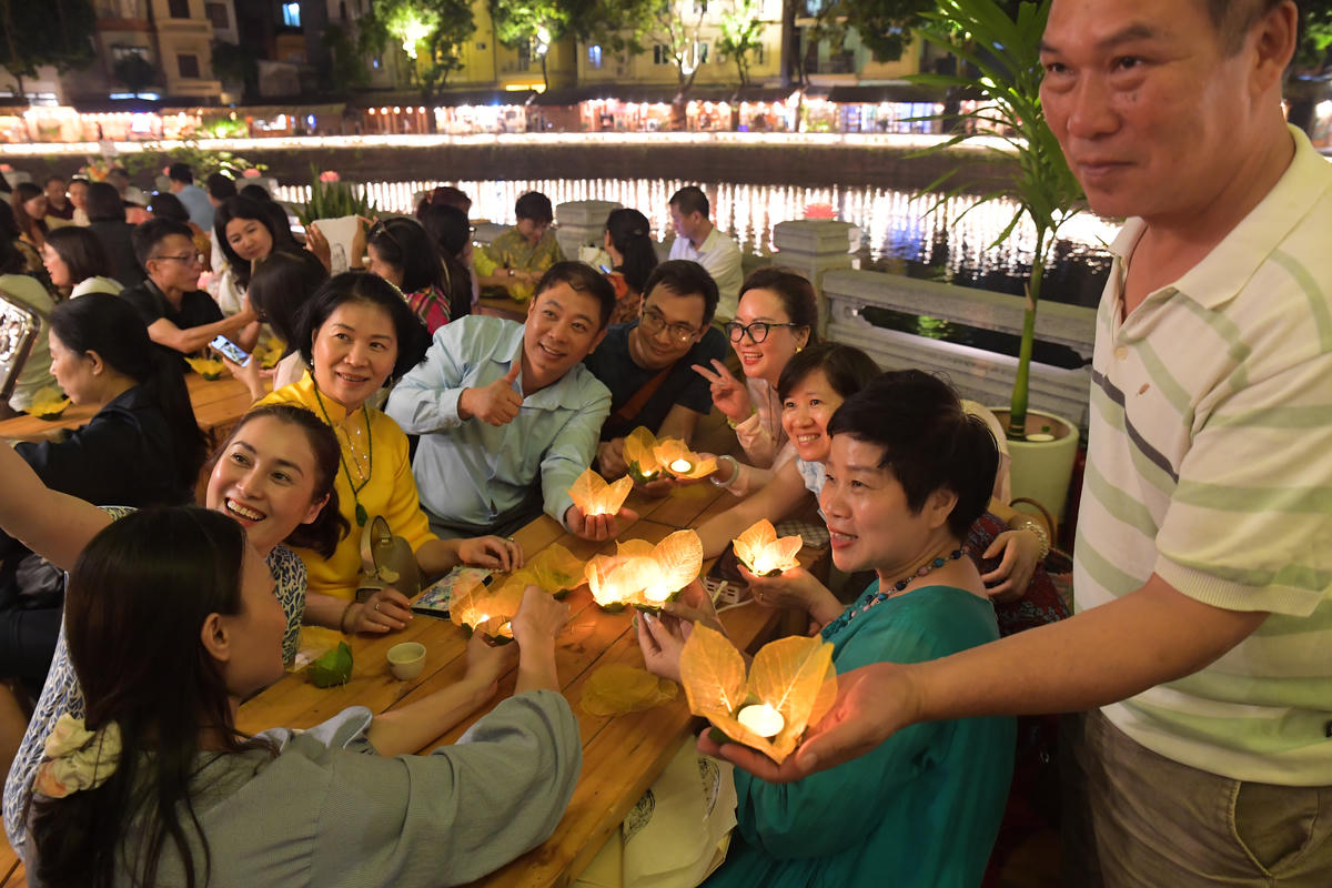 Du khách thích thú khi đã tự tay hoàn thiện những chiếc đèn hoa đăng và thắp lên những ngọn nến lung linh.