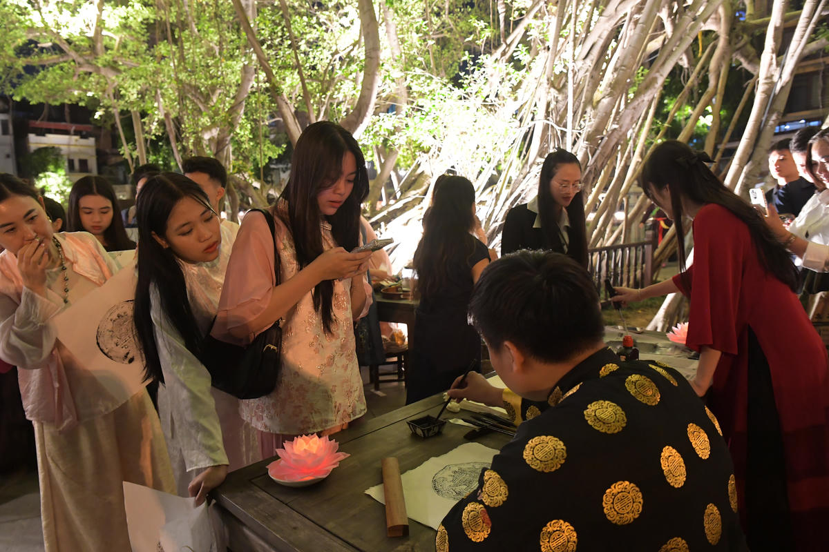 Hoạt động viết thư pháp thu hút nhiều du khách tham gia, mỗi nét chữ không chỉ thể hiện sự trân trọng tri thức mà còn gửi gắm ước vọng cá nhân trong không gian giàu tính biểu tượng.
