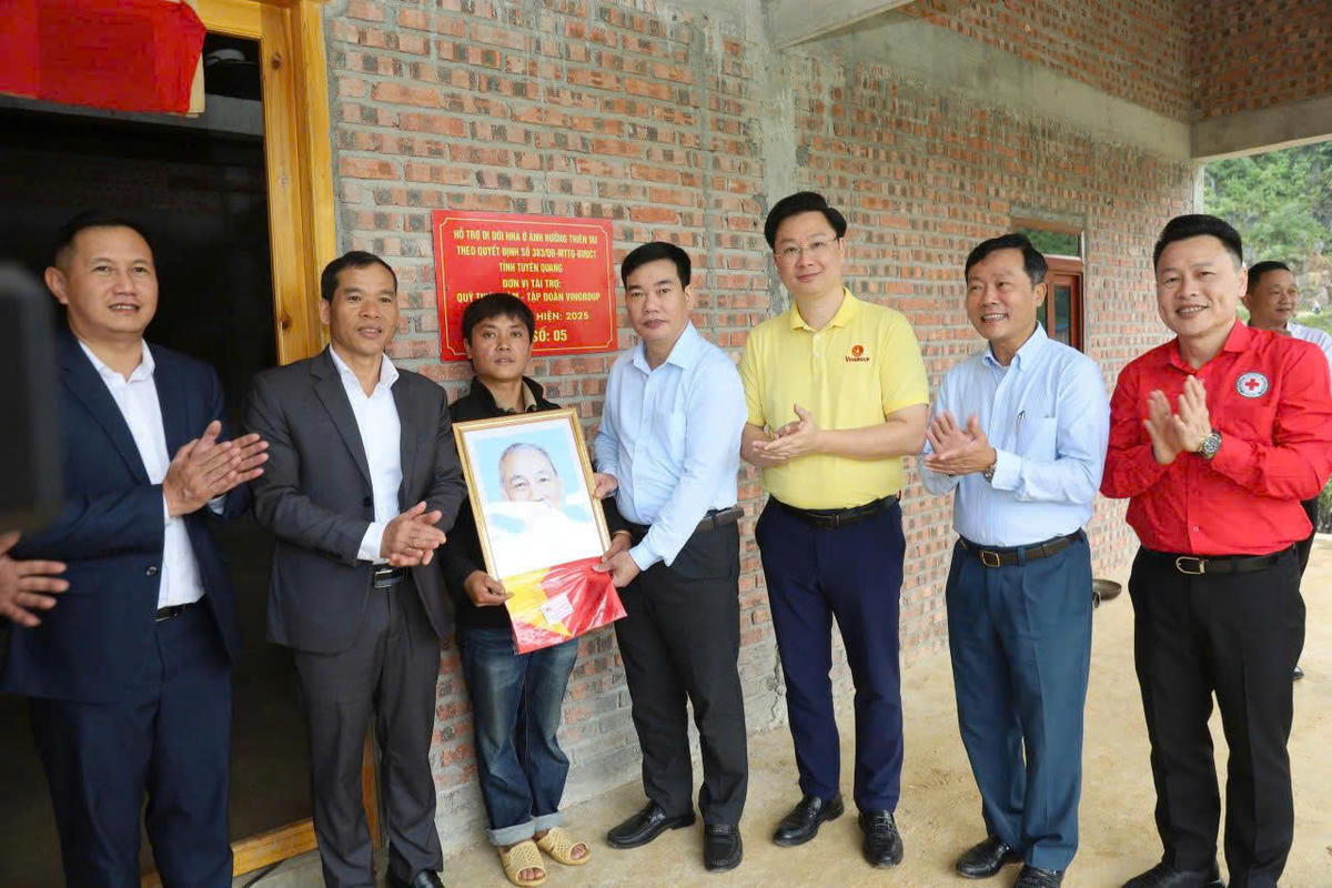 Lãnh đạo Ủy ban MTTQ Việt Nam tỉnh Tuyên Quang cùng các đại biểu tặng Cờ Tổ quốc và ảnh Bác Hồ cho hộ dân.