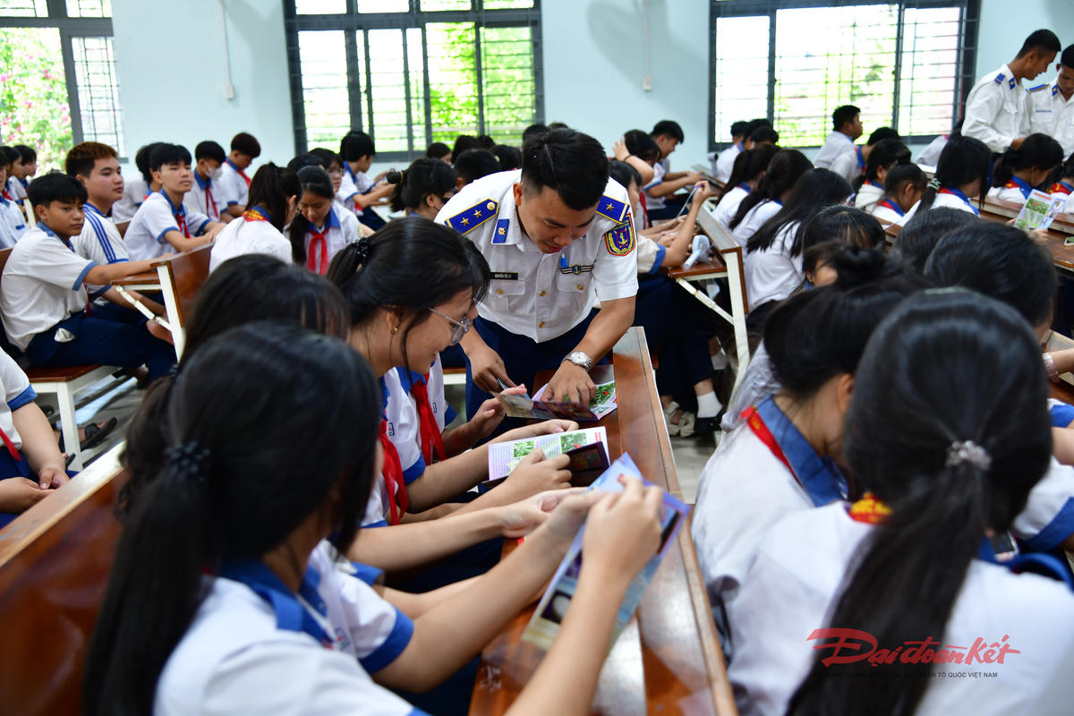 Cảnh sát biển phát tài liệu tuyên truyền về chủ quyền biển đảo và Luật Biển Việt Nam cho học sinh. Ảnh: Hồng Vân.