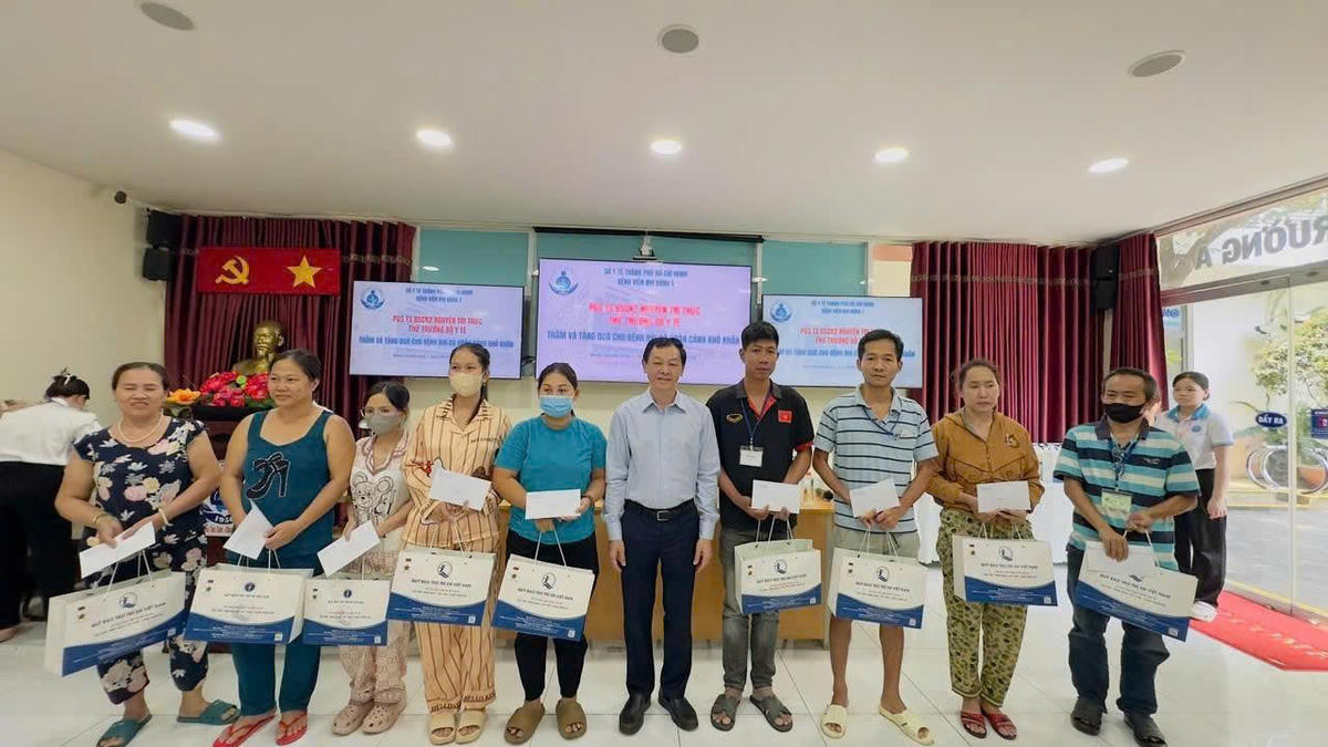 Lãnh đạo Bộ Y tế tặng quà cho gia đình bệnh nhi có hoàn cảnh khó khăn. Ảnh: Vương Long