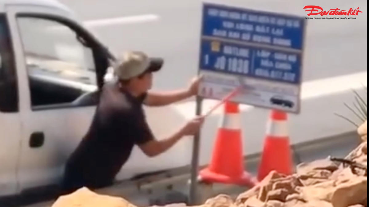 Lê Văn Huấn điều khiển xe tải dừng ở làn khẩn cấp rồi dùng vật giống dao sủi sơn cạo xóa các số điện thoại trên cao tốc Bắc - Nam. Ảnh cắt từ clip.