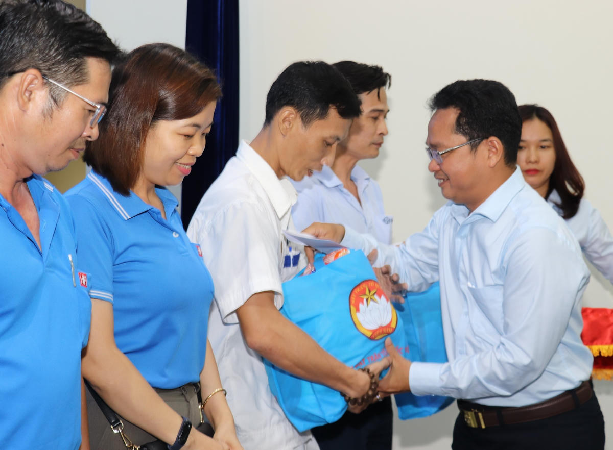 Đại diện lãnh đạo Mặt trận TP Hồ Chí Minh trao quà hỗ trợ cho công nhân bị giảm giờ làm, tạm hoãn hợp đồng lao động, bị mất việc có hoàn cảnh khó khăn. Ảnh: Q.Đ.