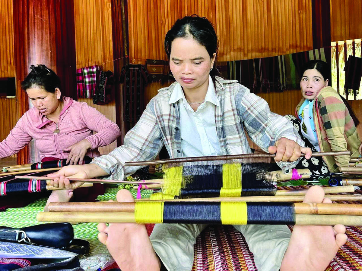 Chị Bloong Thị Tơn đang thêu dệt thổ cẩm tại nhà Gươl. Ảnh: Tấn Thành.