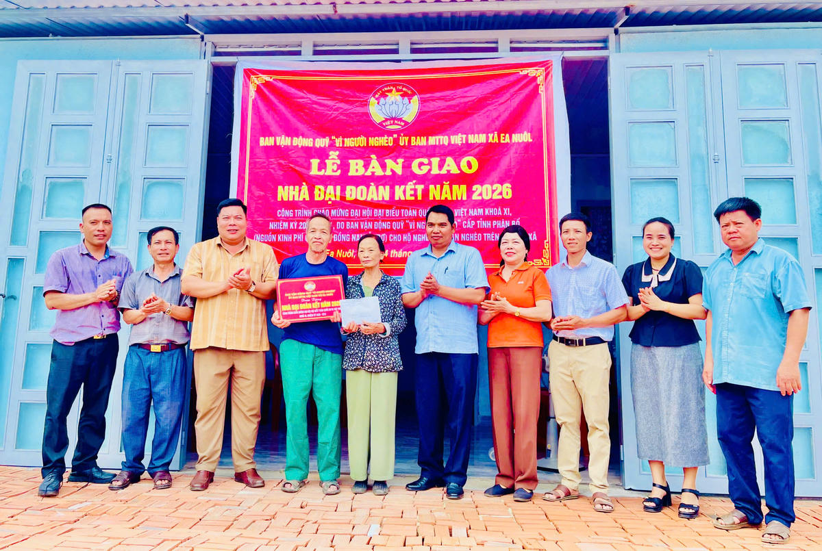 Đại diện Ban Vận động Quỹ “Vì người nghèo” Ủy ban MTTQ Việt Nam xã Ea Nuôl cùng các đại biểu trao bảng tượng trưng và kinh phí hỗ trợ cho hộ bà Hoàng Thị Sim. Ảnh: TT.
