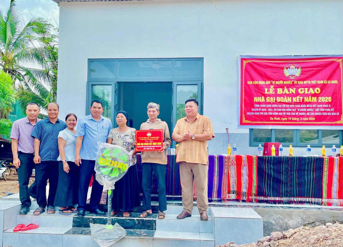 Đại diện Ban Vận động Quỹ “Vì người nghèo” Ủy ban MTTQ Việt Nam xã Ea Nuôl cùng các đại biểu trao bảng tượng trưng và quà hỗ trợ cho hộ gia ông hộ ông Nay Mới, Buôn Ko Đung A. Ảnh:TT.