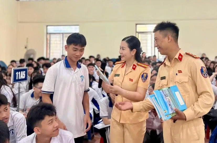 Cán bộ Cảnh sát giao thông phổ biến các quy định cơ bản của Luật Trật tự, an toàn giao thông đường bộ cho các em học sinh. Ảnh: P.C