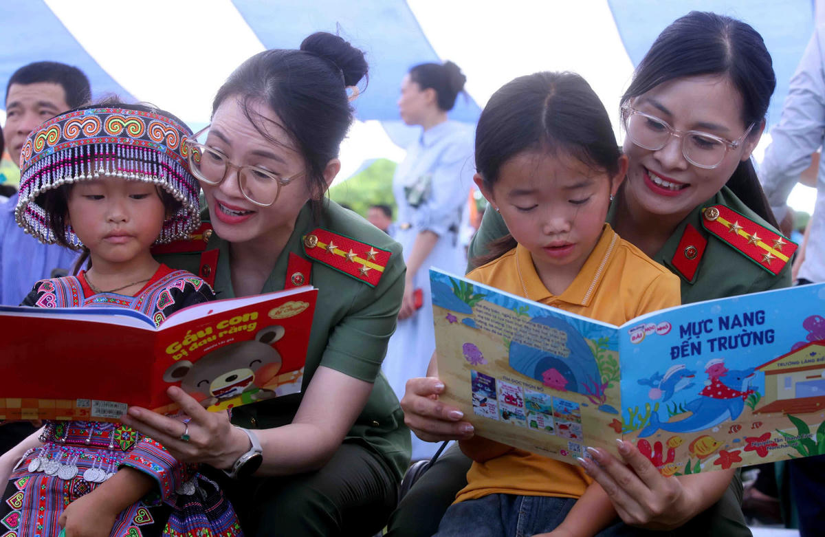 Cán bộ, chiến sĩ CAND trò chuyện, đọc sách cùng các em nhỏ.