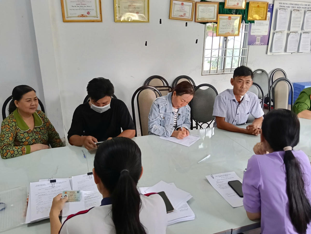 Cán bộ bộ phận đất đai viết giấy tay hướng dẫn người dân từng bước hồ sơ thủ tục hành chính.&nbsp;Ảnh: Nguyên Du
