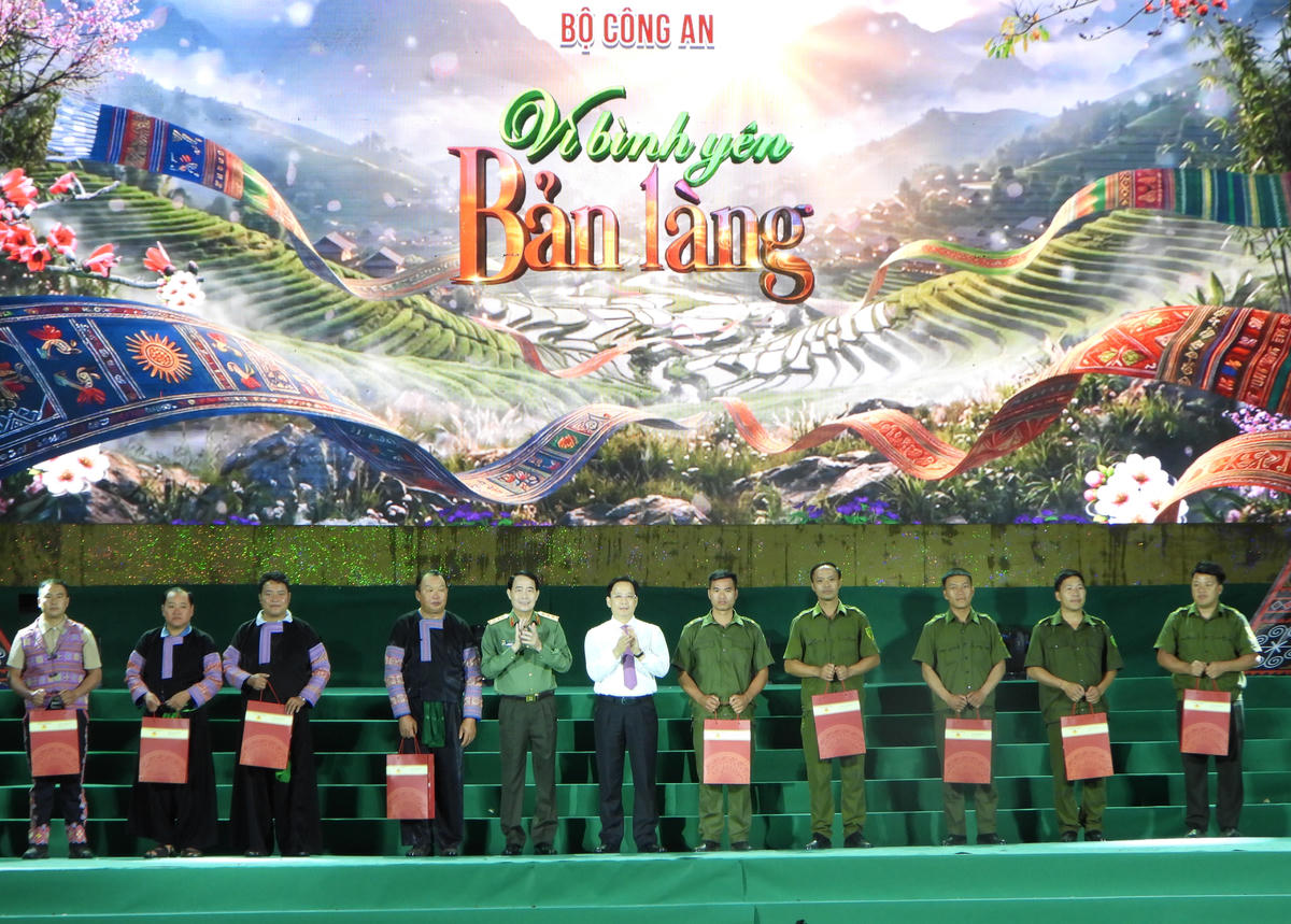 Thứ trưởng Bộ Công an Lê Quốc Hùng cùng Bí thư Tỉnh ủy Sơn La Hoàng Văn Nghiệm tặng quà cho các điển hình trong công tác đảm bảo ANTT tại cơ sở. 