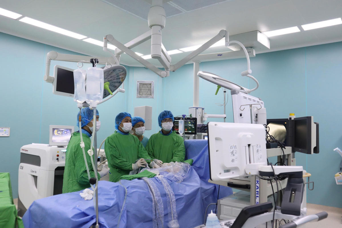 Các bác sĩ thực hiện kỹ thuật tán sỏi đường mật qua đường hầm xuyên gan bằng laser.