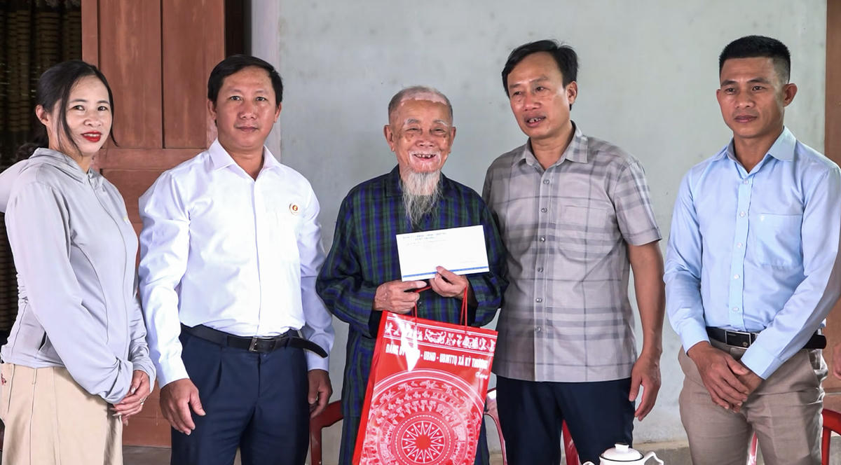 Ông Hoàng Trọng Lý, Bí thư Đảng ủy, Chủ tịch HĐND xã Kỳ Thượng cùng đoàn công tác tặng quà cựu chiến binh Phan Văn Thi. Ảnh: Tiến Quân