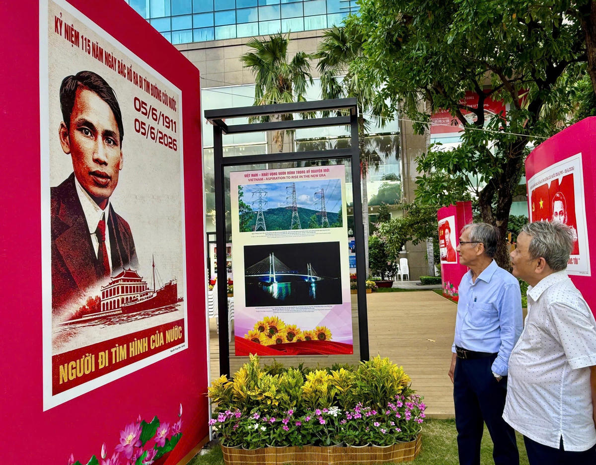 Khách tham quan triển lãm tranh cổ động tấm lớn tuyên truyền kỷ niệm 136 năm Ngày sinh Chủ tịch Hồ Chí Minh và 115 năm ngày Bác Hồ ra đi tìm đường cứu nước. Ảnh: V.Nga.