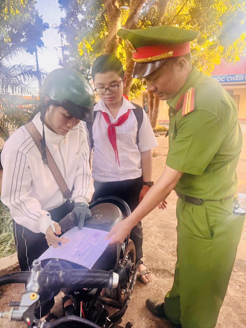 Công an xã Pơng Drang đang cho học sinh và gia đình kí cam kết không vi phạm độ chế xe.