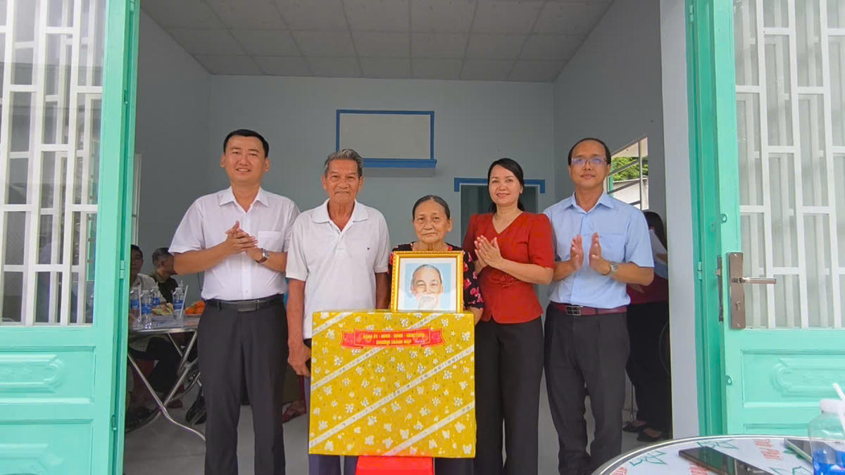 Ngoài trao nhà, phường còn tặng thêm quà và ảnh Bác Hồ cho gia đình bà Rẽ. Ảnh: HC.