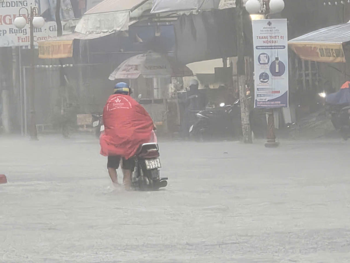 Nhiều phương tiện chết máy phải dẫn bộ qua khu vực ngập sâu. Ảnh: Nguyên Du