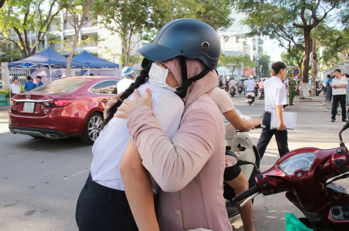 Phụ huynh động viên con cái tự tin làm bài thi. Ảnh: CĐ.