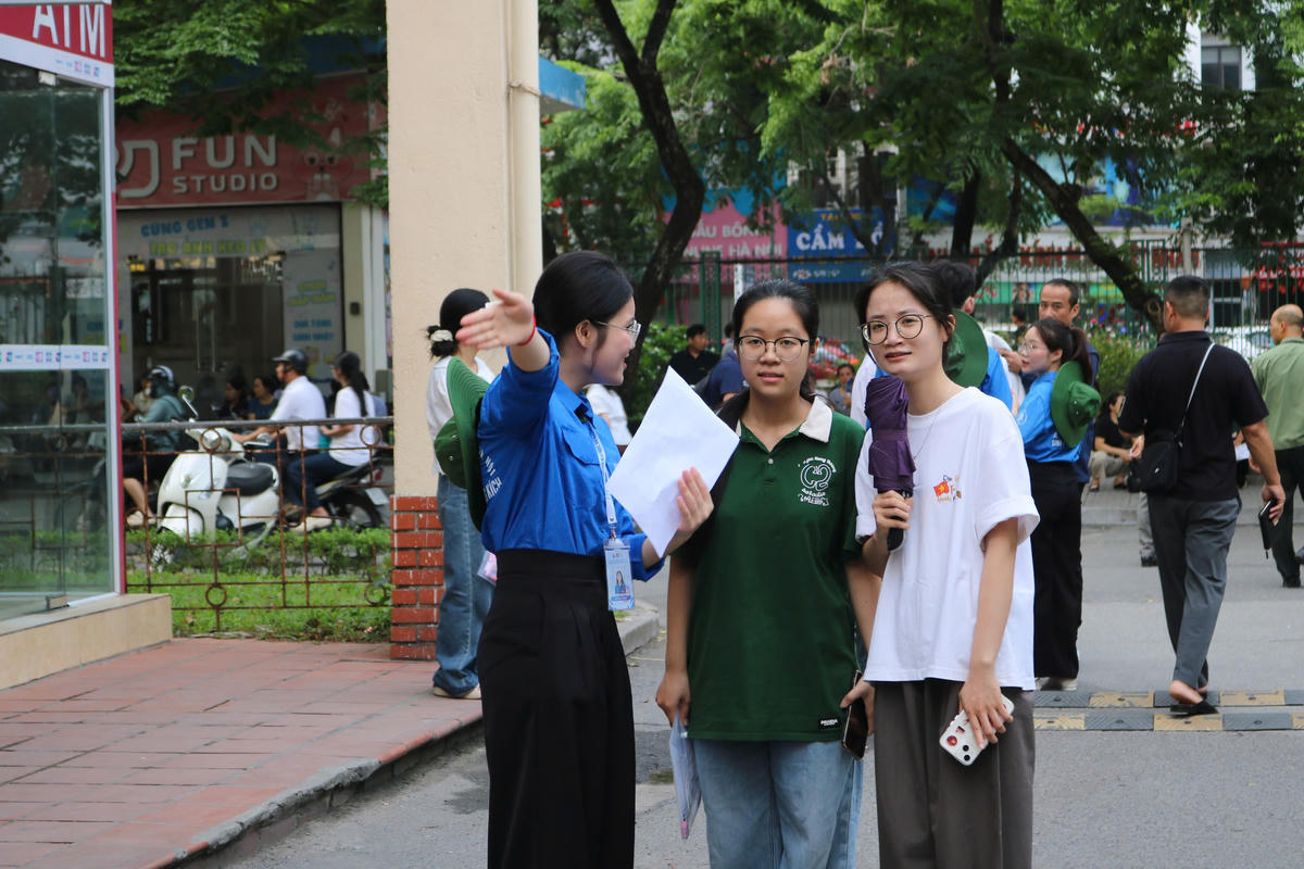 Tình nguyện viên hướng dẫn thí sinh vào phòng thi.
